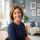 A friendly, diverse woman smiling in a bright, modern living room with soft blue home decor accents.